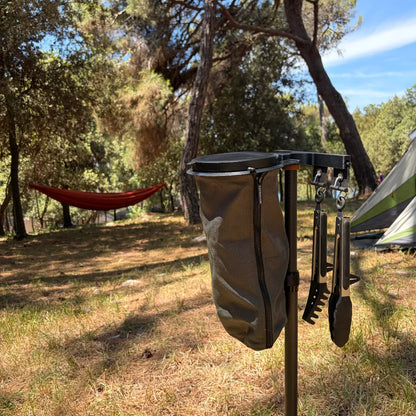 SheltaFlex FlexDock Duo Komplettsystem mit Flextrash Abfallbehälter neben einem Zelt im sonnigen Sommerwald, im Hintergrund eine Hängematte.
