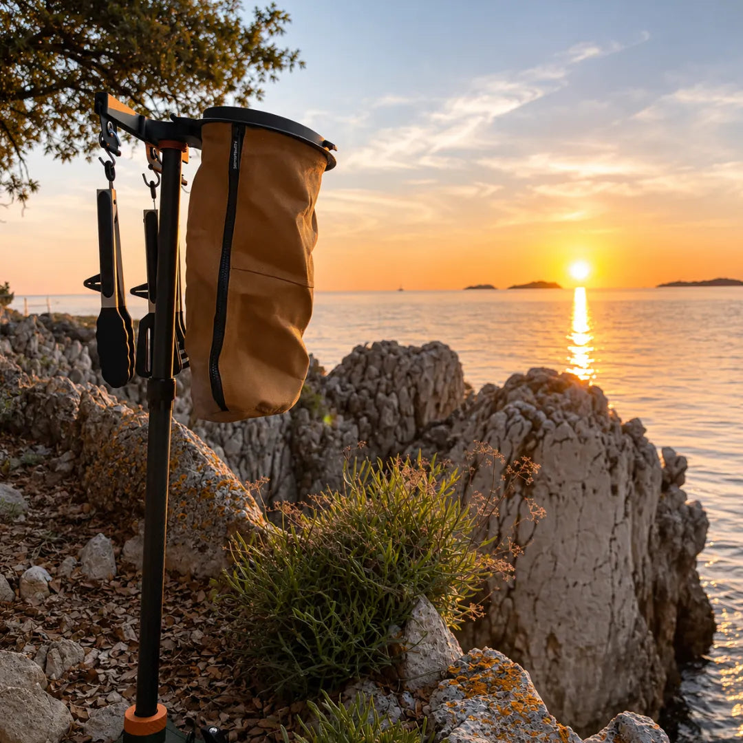 SheltaFlex FlexDock Duo Komplettsystem mit Base, Carbon-Teleskopstange, Flextrash Abfallbehälter und KederRail an der steinigen Küste Kroatiens bei Sonnenuntergang.