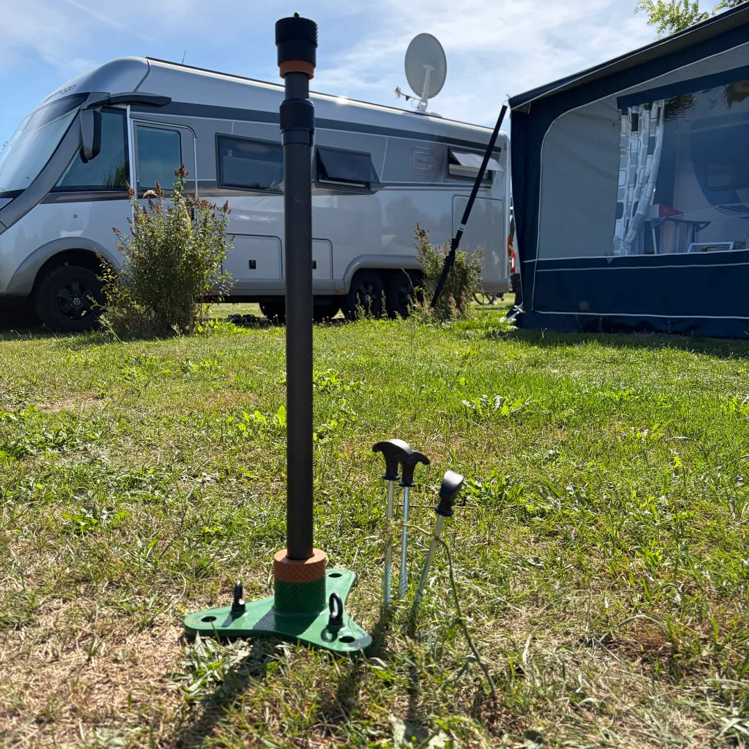 ollständige Produktansicht des SheltaFlex FlexMount mit Base und ausgefahrener Teleskopstange auf einem Campingplatz.