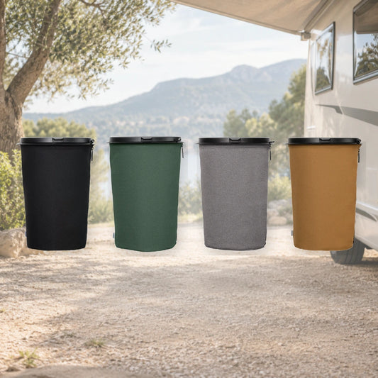 Vier Flextrash 9-Liter-Abfallbehälter in Schwarz, Grün, Grau und Braun vor einem Wohnmobil auf einem Campingplatz.