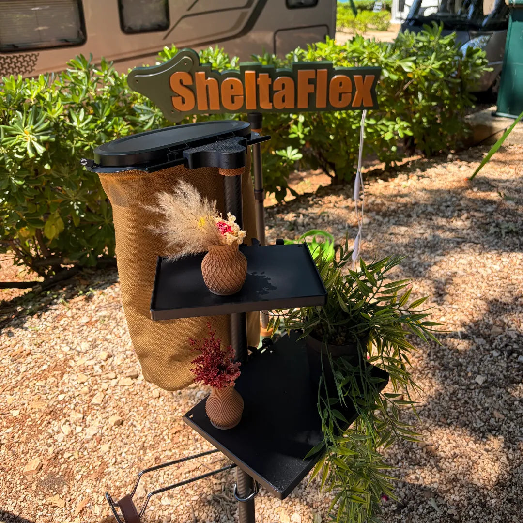 SheltaFlex FlexTray Set mit FlexTray Maxi und FlexTray Compact an der Carbon-Teleskopstange, dekoriert mit Flextrash Abfallbehälter – im Hintergrund das beleuchtete SheltaFlex Logo.