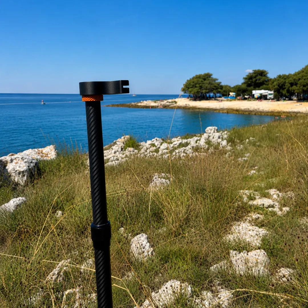 SheltaFlex TrashDock Adapter an der Carbon-Teleskopstange direkt am Meer – praktische Halterung für Flextrash Abfallbehälter beim Camping.
